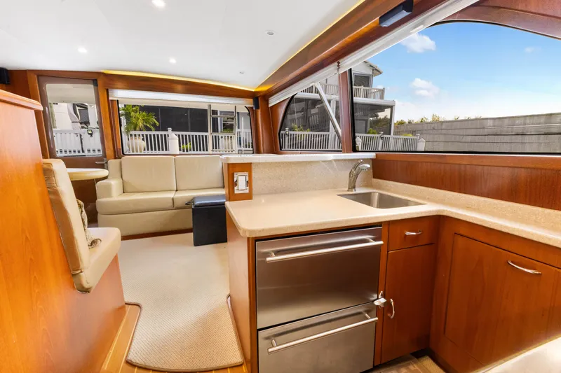 Well Played Yacht Photos Pics Luxurious interior of 2011 Cabo 40 Flybridge yacht with modern kitchen and seating area.