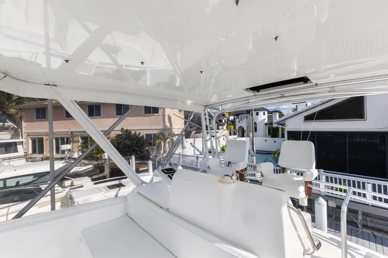 Well Played Yacht Photos Pics Flybridge interior of 2011 Cabo 40, featuring white seating and marina view.