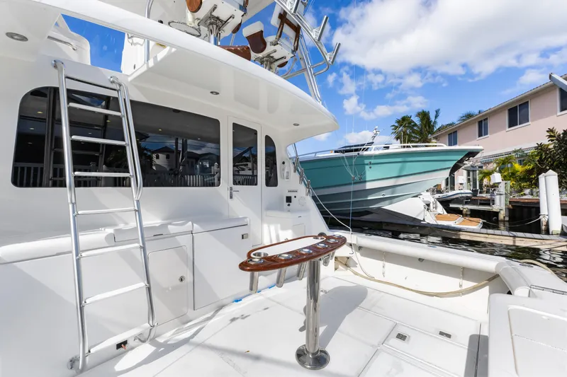 Well Played Yacht Photos Pics 2011 Cabo 40 Flybridge yacht docked, featuring spacious deck and ladder under clear sky.