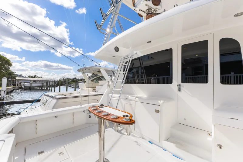 Well Played Yacht Photos Pics 2011 Cabo 40 Flybridge yacht with spacious deck and ladder, docked under a blue sky.
