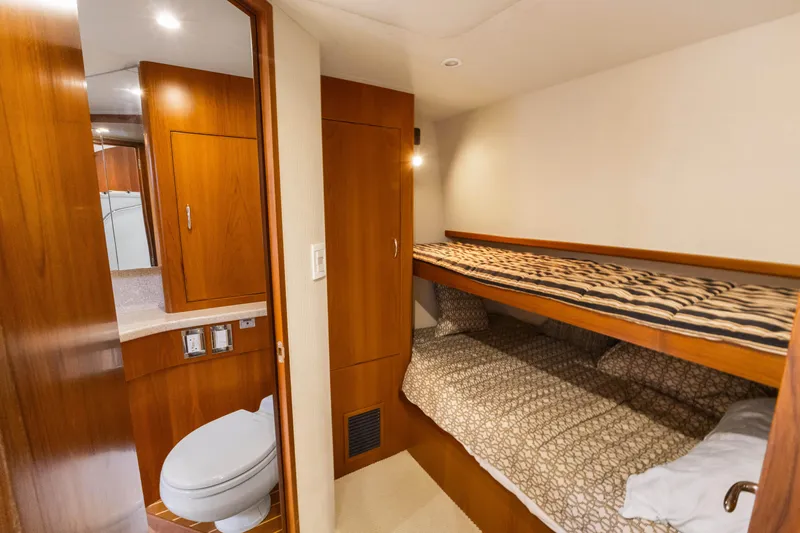 Well Played Yacht Photos Pics Interior of 2011 Cabo 40 Flybridge yacht with bunk beds and wooden cabinetry.