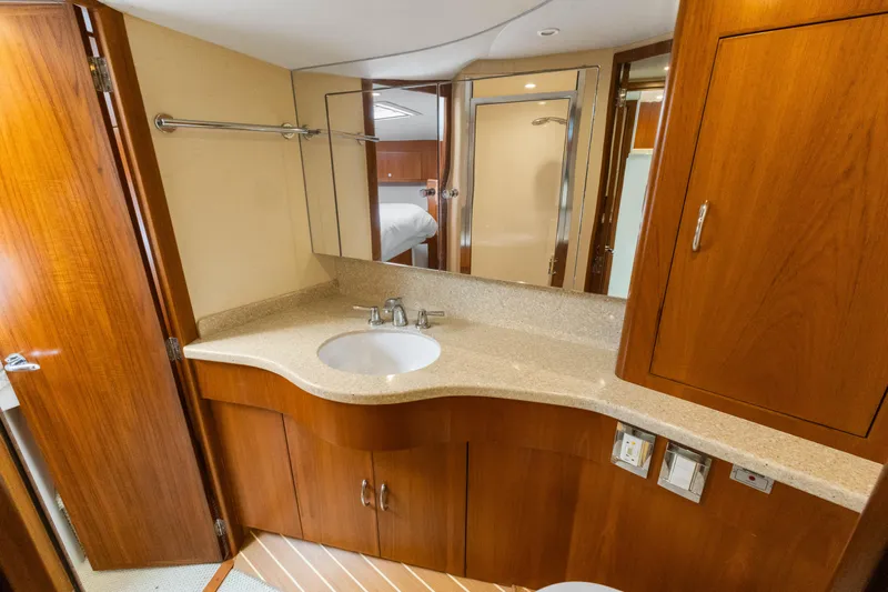 Well Played Yacht Photos Pics Luxurious bathroom in 2011 Cabo 40 Flybridge yacht with wooden cabinetry and modern fixtures.