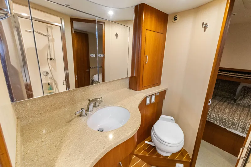 Well Played Yacht Photos Pics Luxurious bathroom in 2011 Cabo 40 Flybridge yacht with modern fixtures and wood accents.