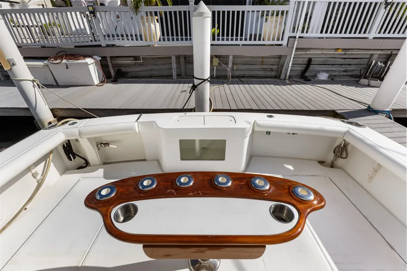 Well Played Yacht Photos Pics Cabo 40 Flybridge 2011 boat deck with wooden rod holders and white seating area.