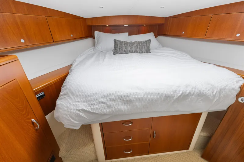 Well Played Yacht Photos Pics Luxurious cabin interior of 2011 Cabo 40 Flybridge yacht with cozy bed and wooden cabinetry.