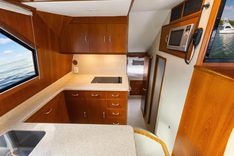 Well Played Yacht Photos Pics Interior of 2011 Cabo 40 Flybridge yacht with modern kitchen and wood cabinetry.