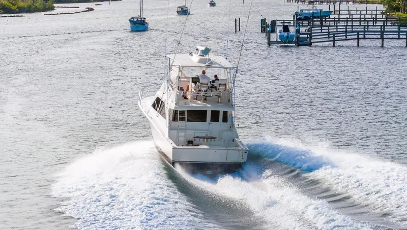 Well Played Yacht Photos Pics Cabo 40 Flybridge 2011 cruising on a scenic waterway, leaving a wake behind.