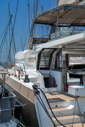 Cinders Yacht Photos Pics Luxury Bali 5.4 catamaran docked at marina, showcasing spacious deck and modern design, 2020 model.