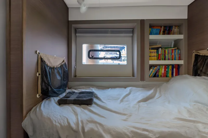 Cinders Yacht Photos Pics Cozy cabin interior with bed, window, and bookshelf on a 2020 Bali 5.4 model.