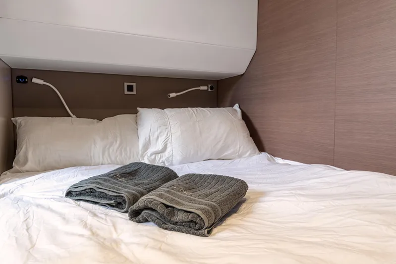 Cinders Yacht Photos Pics Cozy cabin bed in Bali 5.4 yacht, 2020 model, with white linens and folded towels.