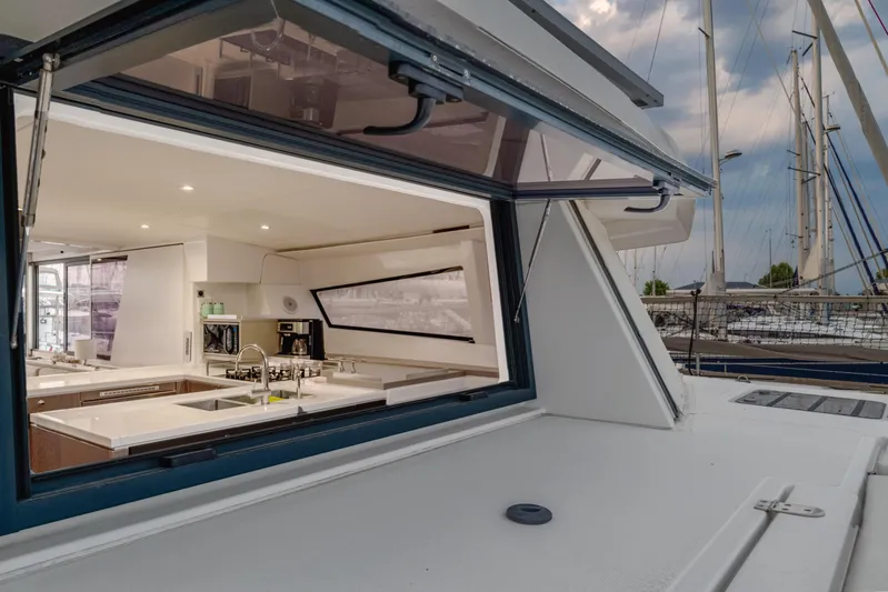 Cinders Yacht Photos Pics Modern Bali 5.4 yacht kitchen interior with open window, showcasing sleek design and marina view.
