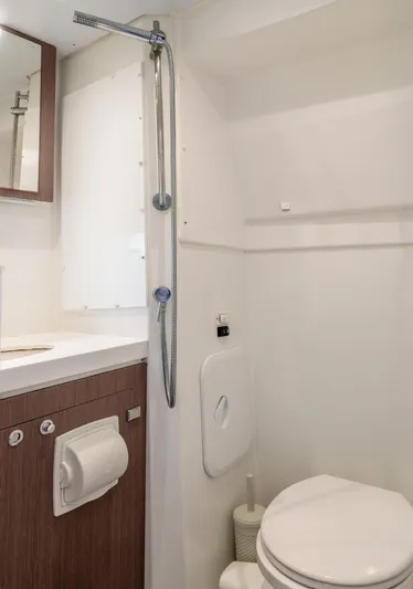Cinders Yacht Photos Pics Compact bathroom in a 2020 Bali 5.4 model, featuring a shower, toilet, and wooden cabinetry.