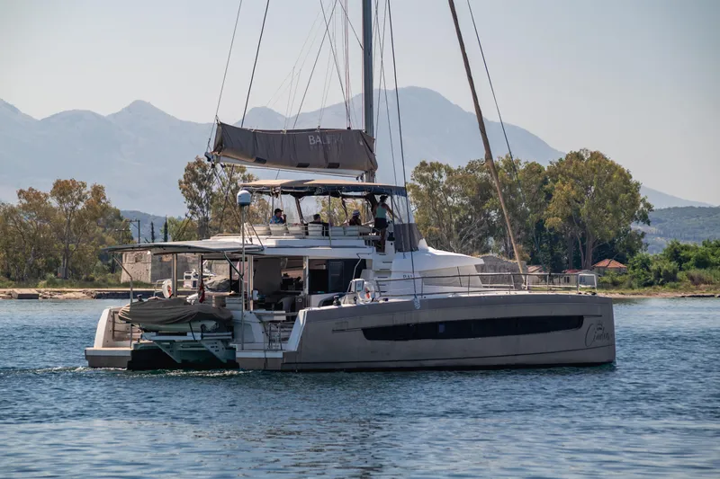 Cinders Yacht Photos Pics 2020 Bali 5.4 catamaran sailing near scenic mountains and lush greenery.