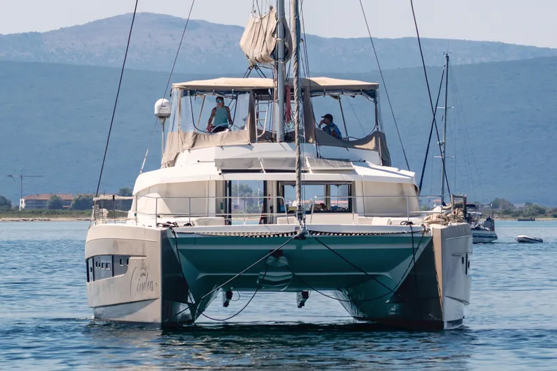 Cinders Yacht Photos Pics Catamaran Bali 5.4 sailing on calm waters with mountainous backdrop, 2020 model.