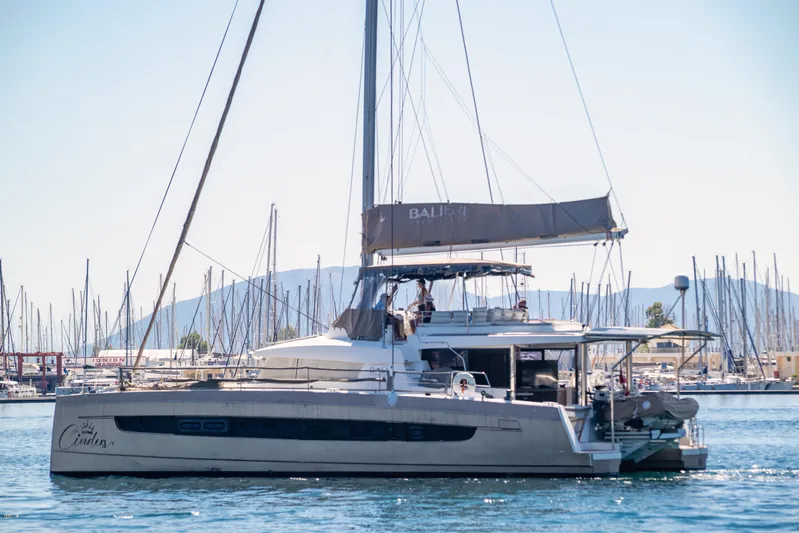 Cinders Yacht Photos Pics 2020 Bali 5.4 catamaran sailing in a marina with mountains in the background.