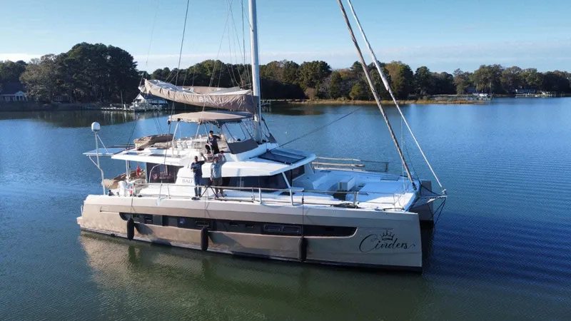 Cinders Yacht Photos Pics 2020 Bali 5.4 catamaran sailing on a calm lake with lush green surroundings.