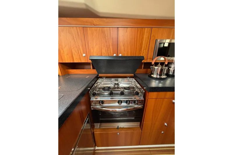  Yacht Photos Pics Modern kitchen in 2017 Hanse 455 yacht with stove and wooden cabinetry.
