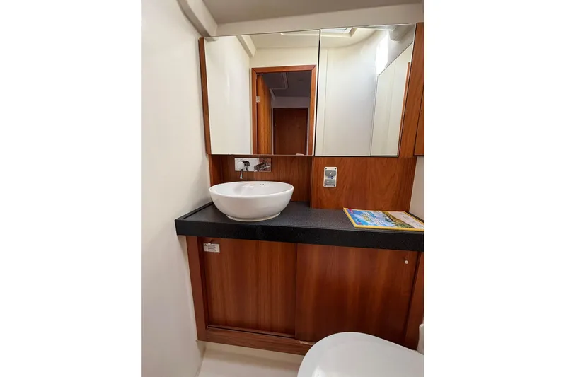  Yacht Photos Pics Modern bathroom interior on 2017 Hanse 455 yacht with wooden cabinetry and vessel sink.