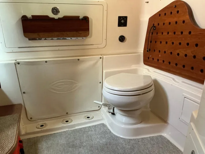 H Lady Frances Yacht Photos Pics 2011 Grady-White Canyon 336 boat interior with toilet and wooden storage panel.