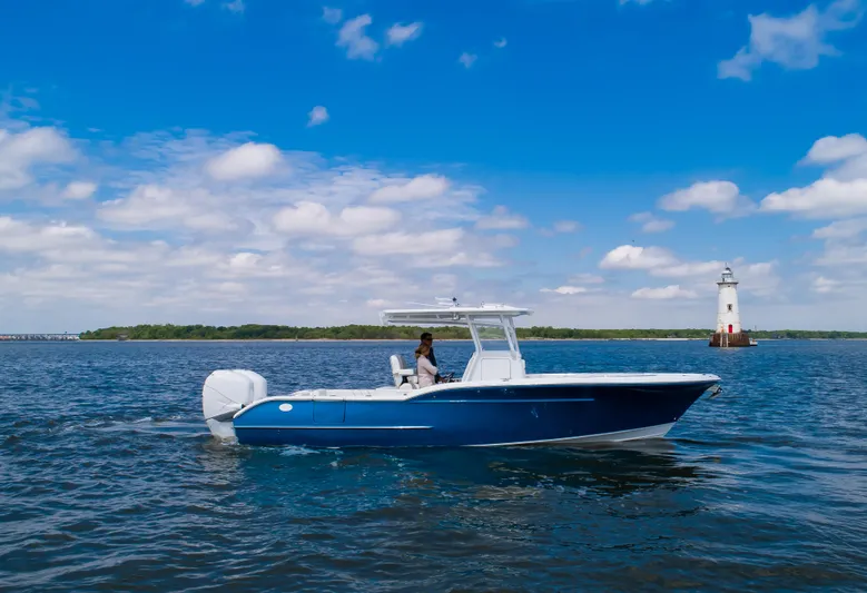  Yacht Photos Pics 2025 Buddy Davis 28 Center Console boat on open water near lighthouse.