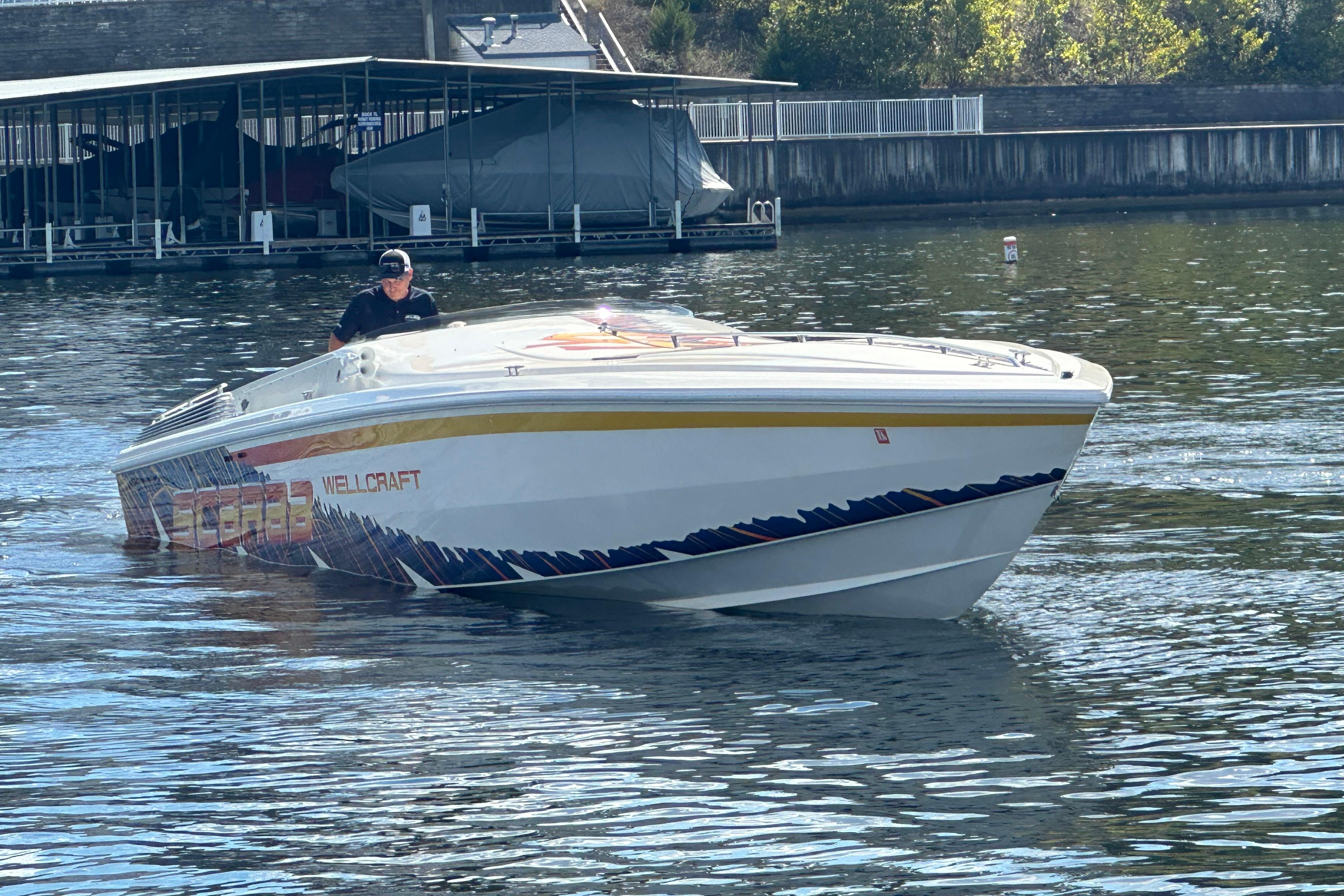1995 Excel Scarab 43 boat on water, featuring Wellcraft branding and vibrant design.