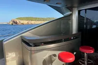 Luxury yacht AB 140 (2011) with sleek bar and red stools, ocean view.