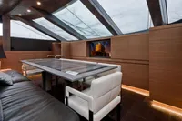 Luxurious yacht interior with skylights, modern seating, and a sleek table. AB 140, 2011 model.