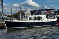 Custom Belter 1240 boat from 2002 docked at a marina under a blue sky.