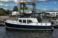 Custom Belter 1240 boat, 2002 model, docked at Jachthaven Meppel B.V. under a cloudy sky.
