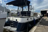 Custom Belter 1240 boat docked at marina, 2002 model, with blue canopy and fenders.