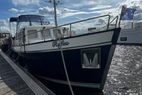 Custom Belter 1240 boat docked, displaying Australian flag, under a partly cloudy sky.