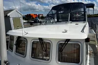 Custom Belter 1240 boat docked at marina, showcasing upper deck and windows, 2002 model.