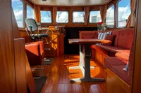 Luxurious interior of 2002 Custom Belter 1240 boat with wooden furnishings and seating.