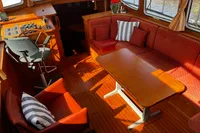 Luxurious interior of 2002 Custom Belter 1240 boat with cozy seating and wooden decor.