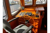 Pilothouse interior of 2002 Custom Belter 1240 boat with wooden steering wheel and control panel.