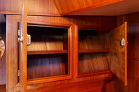 Wooden cabinets with open doors on a Custom Belter 1240, 2002 model.