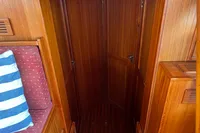 Wooden interior of 2002 Custom Belter 1240 boat with striped cushion.