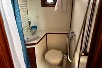 Compact bathroom in 2002 Custom Belter 1240 boat with sink, toilet, and shower.