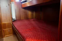 Cozy wooden cabin interior with red polka dot bedding, Custom Belter 1240, 2002.