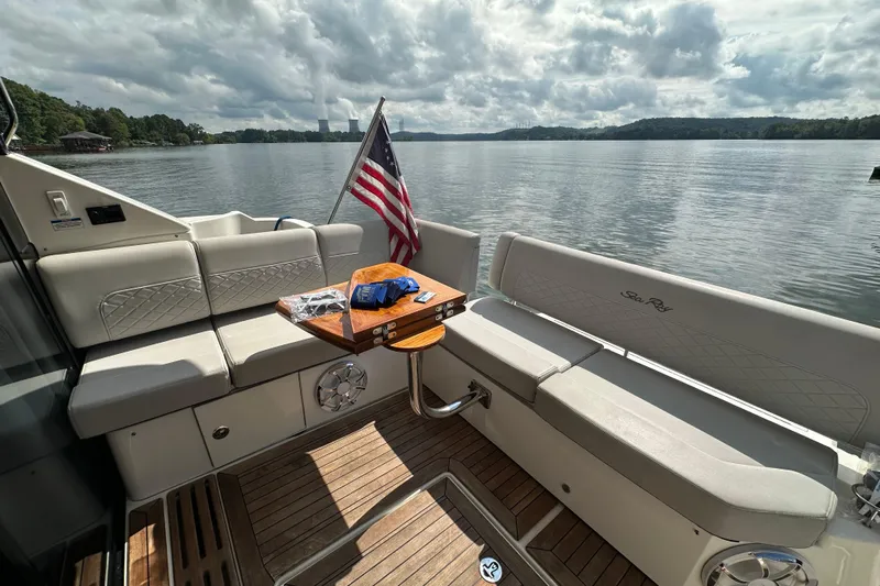  Yacht Photos Pics 2017 Sea Ray Fly 460 yacht interior with seating, table, and American flag on a serene lake.