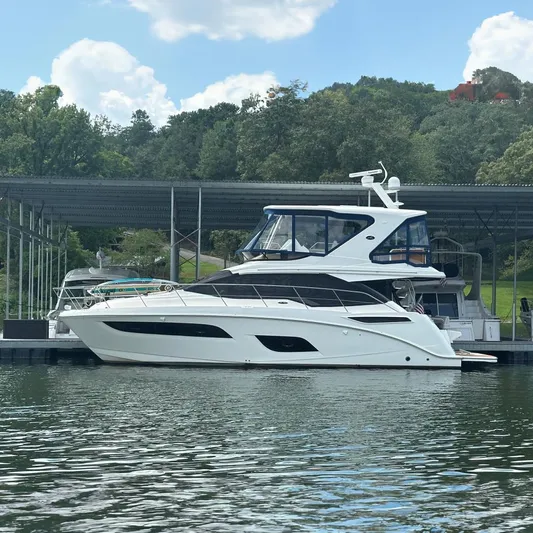  Yacht Photos Pics 2017 Sea Ray Fly 460 yacht docked at marina, surrounded by lush greenery.