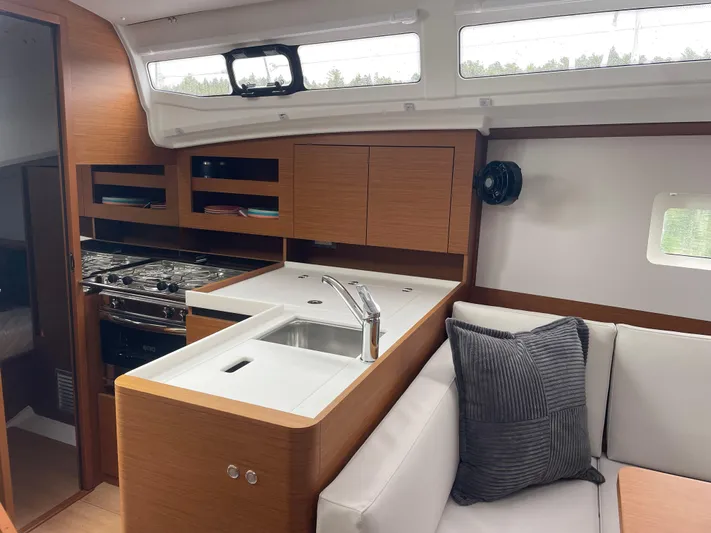  Yacht Photos Pics 2024 Jeanneau Sun Odyssey 380 interior with modern kitchen and cozy seating area.
