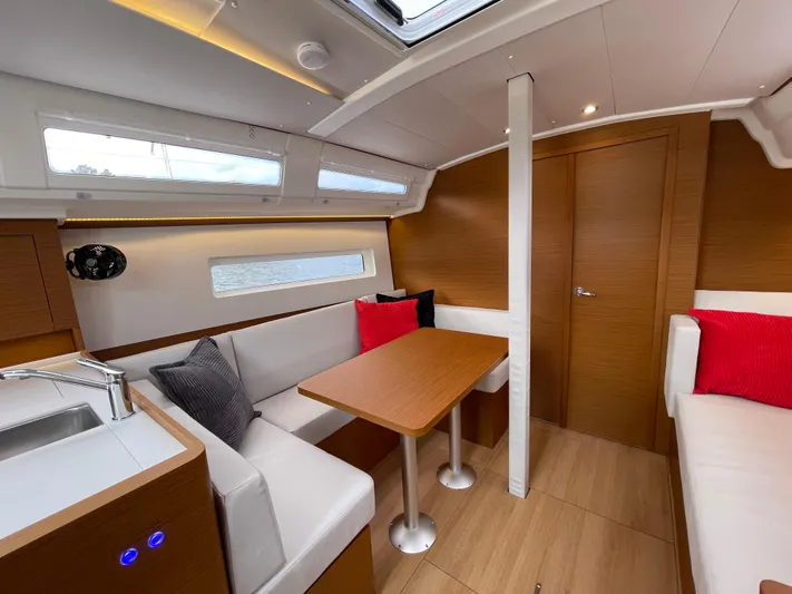  Yacht Photos Pics 2024 Jeanneau Sun Odyssey 380 interior with modern seating, wooden finishes, and natural light.