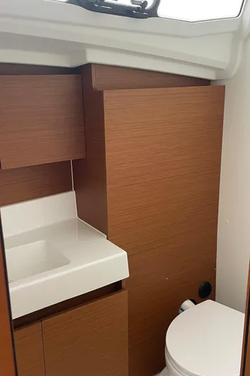  Yacht Photos Pics 2024 Jeanneau Sun Odyssey 380 bathroom with modern wood cabinetry and white fixtures.