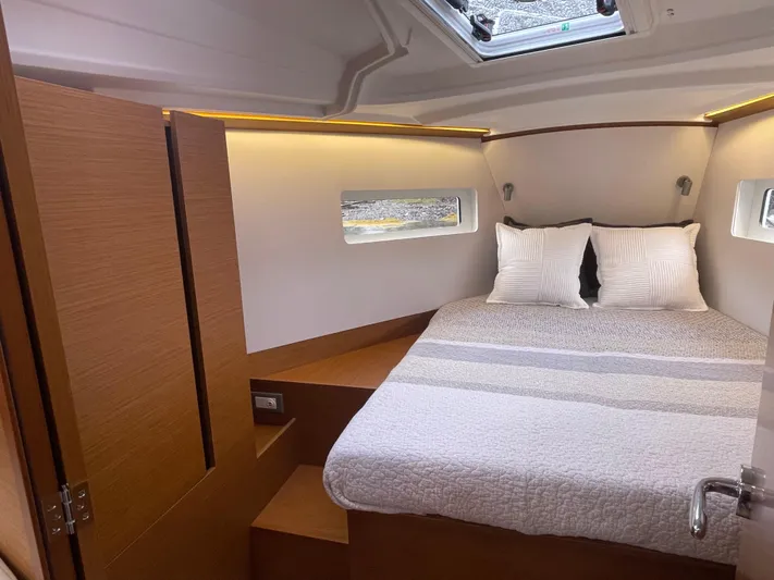  Yacht Photos Pics 2024 Jeanneau Sun Odyssey 380 cabin interior with cozy bed and modern design.