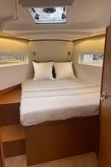  Yacht Photos Pics 2024 Jeanneau Sun Odyssey 380 cabin interior with cozy bed and natural lighting.