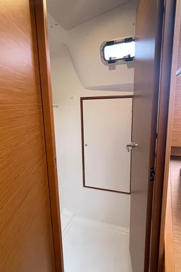  Yacht Photos Pics 2024 Jeanneau Sun Odyssey 380 interior cabin with wooden door and window.