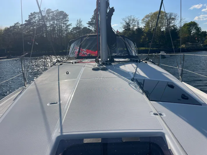  Yacht Photos Pics 2024 Jeanneau Sun Odyssey 380 sailboat deck with scenic water and trees in the background.