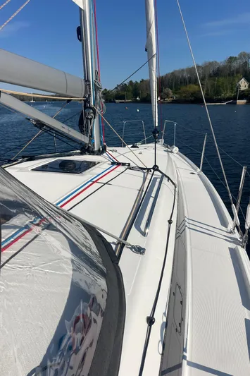  Yacht Photos Pics 2024 Jeanneau Sun Odyssey 380 sailboat on calm water, showcasing sleek deck design.