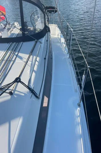  Yacht Photos Pics 2024 Jeanneau Sun Odyssey 380 sailboat deck with sleek design on calm water.